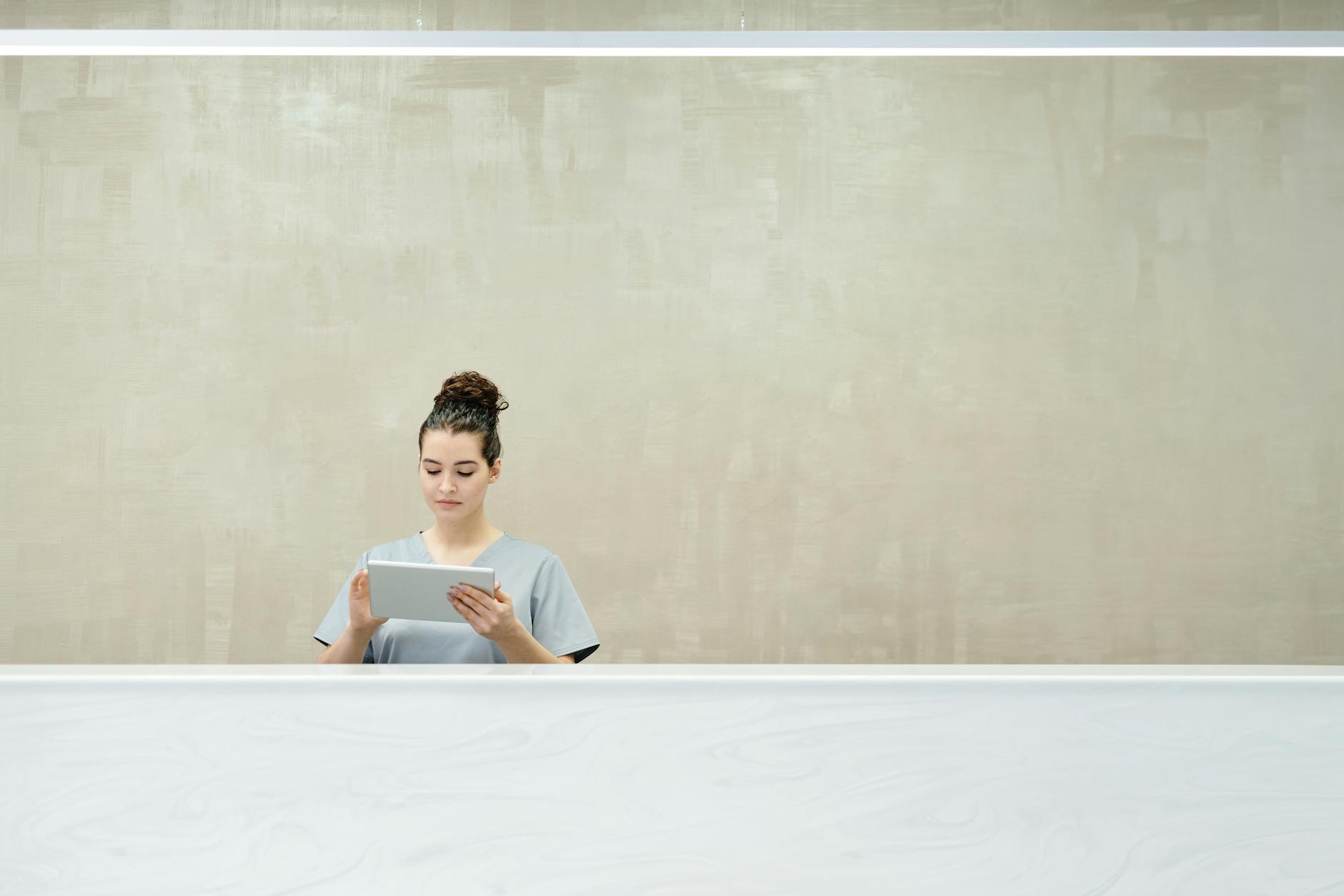 Recepcjonistka w nowoczesnym biurze testuje tablet do obsługi klientów