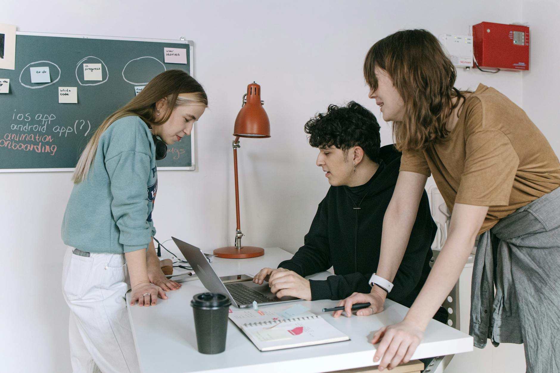 Zespół młodych developerów omawia rozwiązania DevOps w nowoczesnym biurze