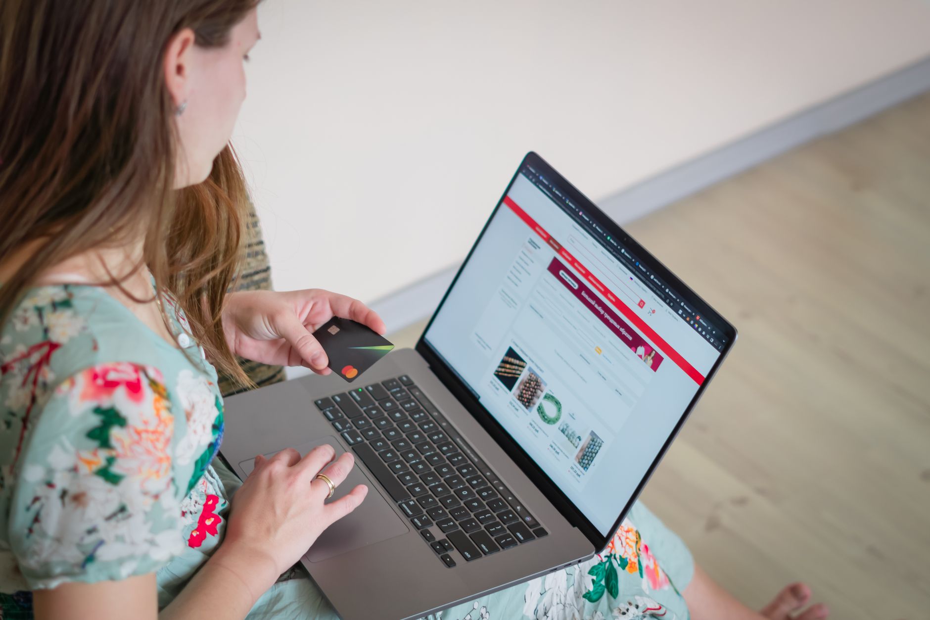 AI w konfiguratorach mebli na stronie www: mniej zwrotów, więcej sprzedaży Kobieta w kwiecistej sukience robi zakupy online przy laptopie